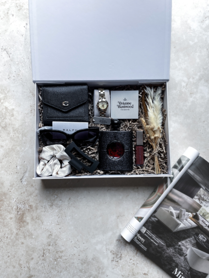 White A4 luxury gift box with items inside for a women. Items such as a wallet, watch, perfume, lip gloss and accessories presented in a white magnetic A4 gift box