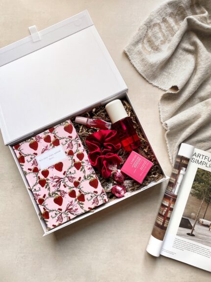 A beautifully curated sweet self-care gift set with beauty essentials, a floral notebook, and chocolates in a premium gift box.