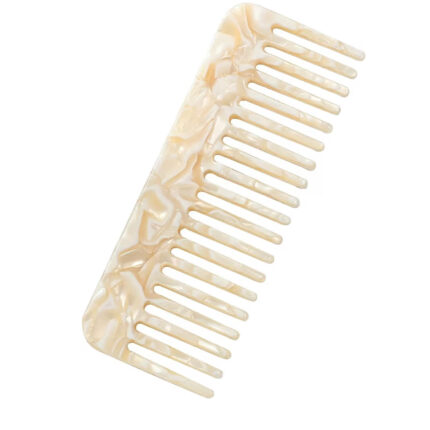 Cream wide-tooth hair comb on neutral background