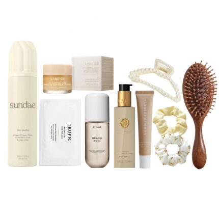 Flat lay of the Soaked And Fresh Gift Box items including shower foam, under-eye patches, lip care, hand balm, hair accessories, and more in a white SOMETHING HER gift box.