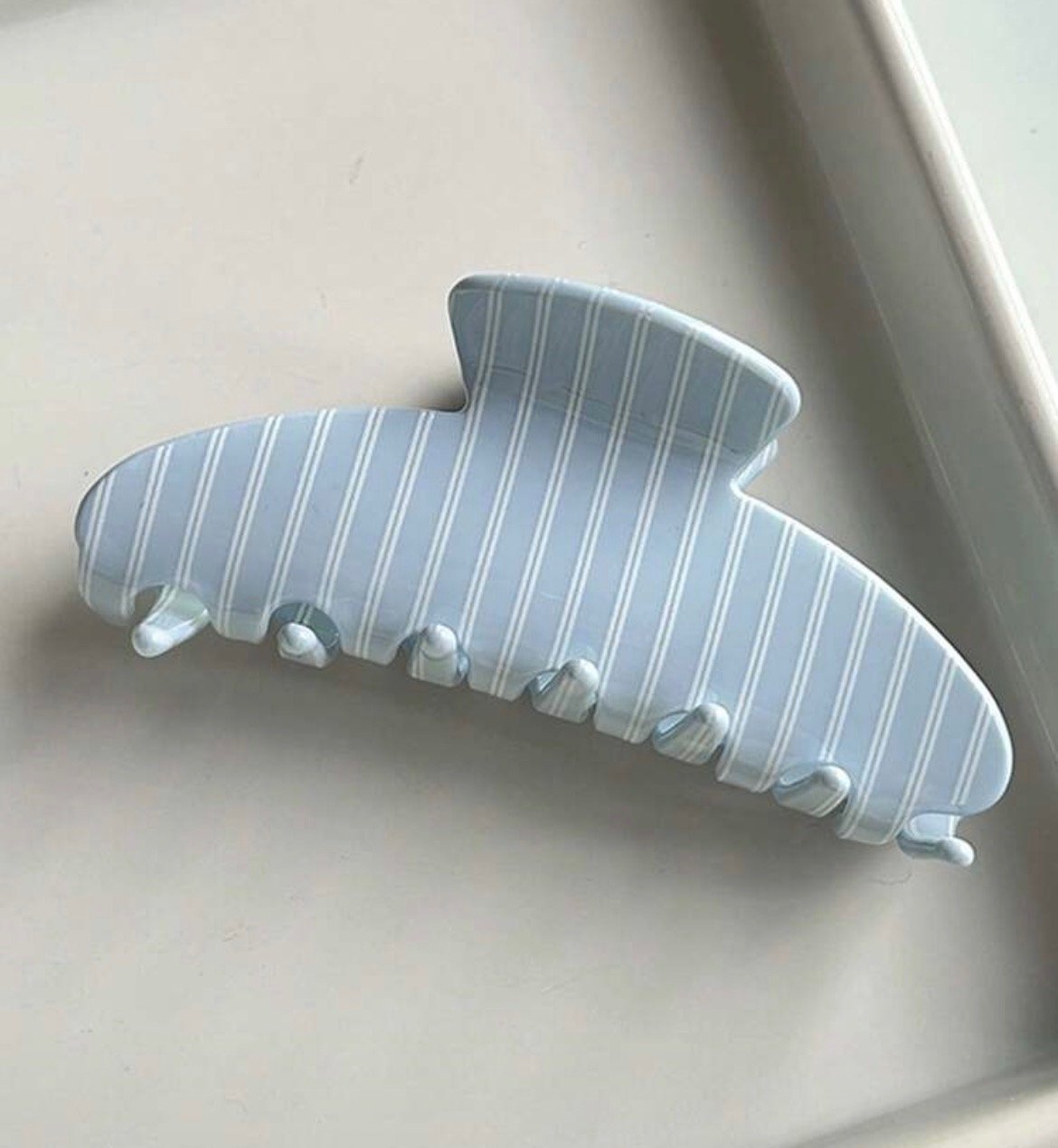 Screenshot Striped blue oval claw clip hair accessory for secure and stylish everyday hairstyles.