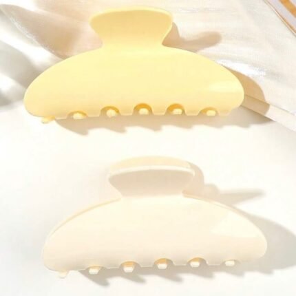 Matte creamy white oversized claw clip hair accessory on white satin fabric