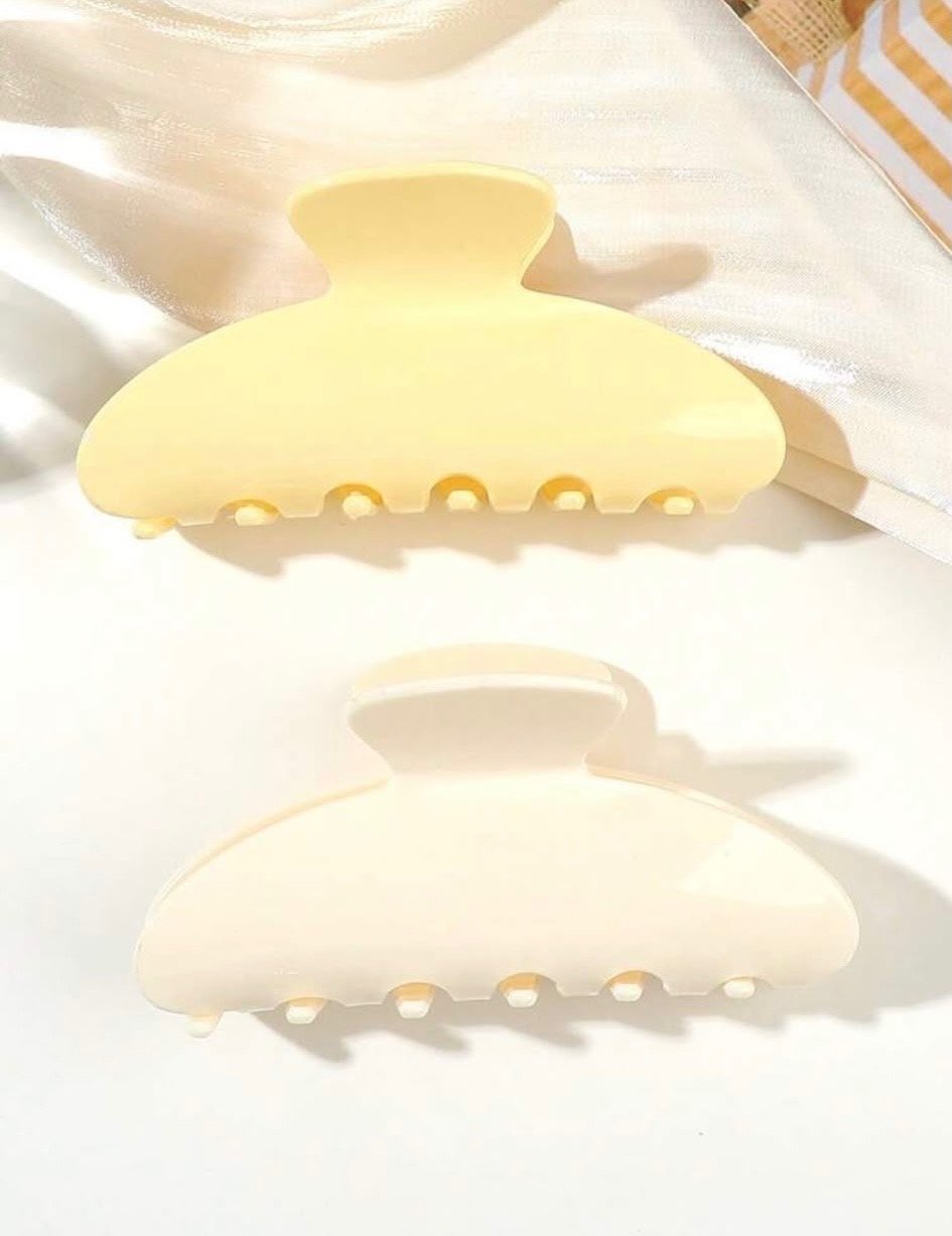 bad4cbe7-9551-44b3-be6b-53617b5ef310 Matte creamy white oversized claw clip hair accessory on white satin fabric